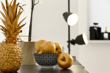 Golden fruits on dark table in room