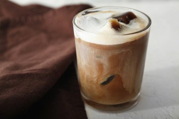 Glass of cold coffee on light table