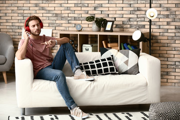 Fototapeta premium Young man listening to music at home