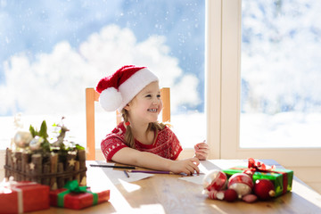 Child writing letter to Santa. Present wish list.