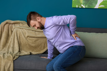 Man suffering from back pain at home