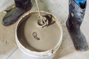 Man making cement with a construction mixer in a bucket