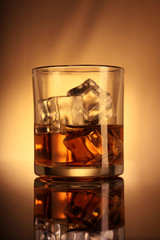 Single whiskey glass with ice cubes
