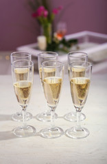 Glasses of champagne on white wooden table