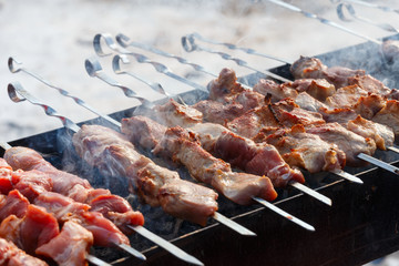 Meat with sharp skewers at barbecue in winter