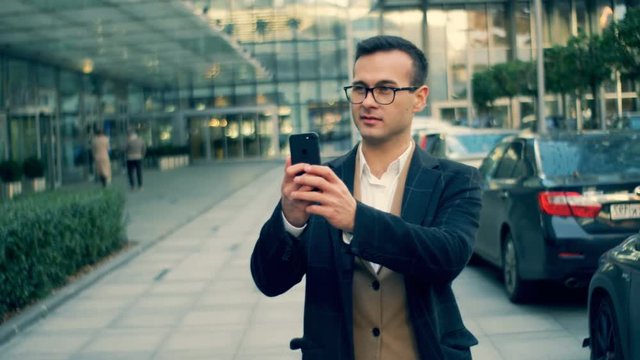Businessman takes photos with a phone, close up.