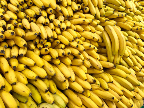 Many fresh fruits yellow bananas in supermarket, food concept background