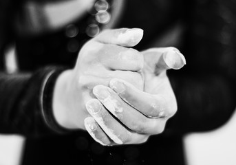 Young gymnast applying a powdered chalk to her palms