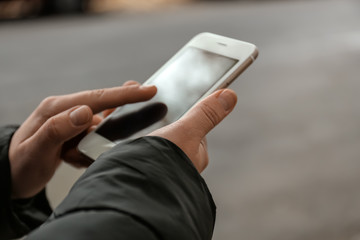 Young woman using mobile phone outdoors, closeup