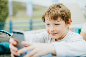 Happy boy playing on a mobile phone © Rawpixel.com