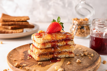 Wooden plate with sweet toasts on table