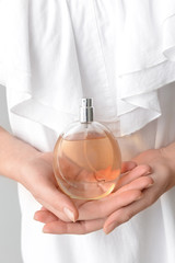 Woman with bottle of aromatic perfume, closeup