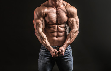 Fototapeta na wymiar Muscular bodybuilder on dark background