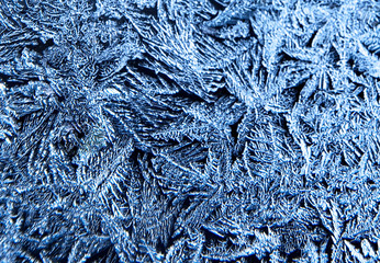 Frosty natural pattern on the window.Frozen patterns on the glass.Winter ice embroidered lace background.Frosted icy texture.
Selective focus.