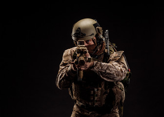 Special forces United States soldier or private military contractor holding rifle. Image on a black background.