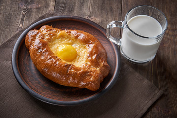 Caucasian kitchen. Khachapuri with the egg and cheese, milk.