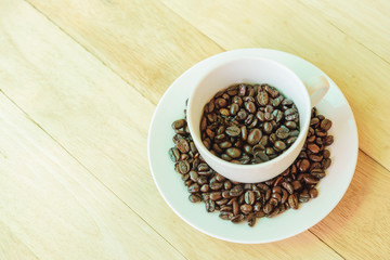 Coffee bean in the cup on wood plate
