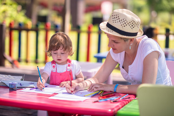 mom and little daughter drawing a colorful pictures