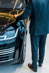 cropped image of businessman choosing car in dealership salon