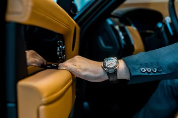 Deurstickers cropped image of businessman with luxury watch closing door while sitting in car © LIGHTFIELD STUDIOS