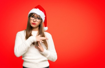 Girl with celebrating the christmas holidays making stop gesture with her hand to stop an act on red background