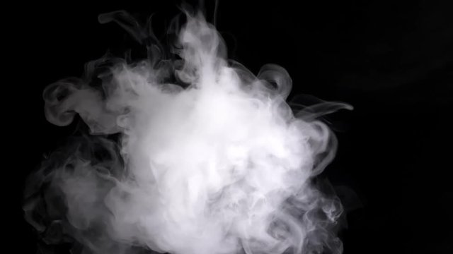 Thick beautiful smoke envelops the black space and slowly moves on a black background attracting the eye and moving