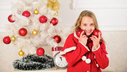 Getting child involved decorating. Girl smiling face hold balls ornaments white interior background. How to decorate christmas tree with kid. Let kid decorate christmas tree. Favorite part decorating