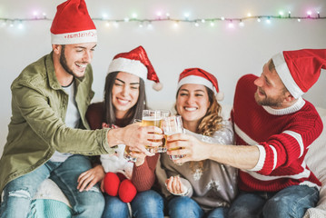 Group of friends cheering with beer at christmas party