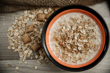 Porridge from different cereals in a plate on a gray wooden background. View from above.