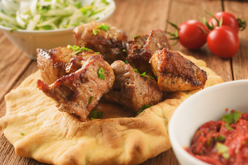 Juicy, hot grilled pork on pita with lettuce, spices, onions and peppers