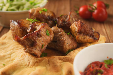 Juicy, hot grilled pork on pita with lettuce, spices, onions and peppers