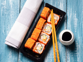 Sushi with shrimp, caviaron and avocado on blue wooden background.
