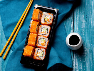 Sushi with shrimp, caviaron and avocado on blue wooden background.
