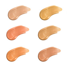 Shades of foundation on white background, closeup of different tones of liquid foundation, makeup product texture. 