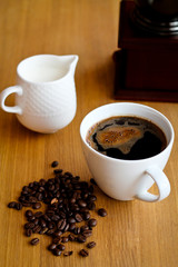 Aromatic fresh coffee in porcelain cup on wooden table