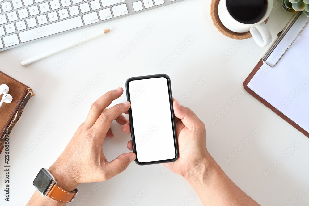 Poster top view of man using mobile phone in office. blank screen for display montage