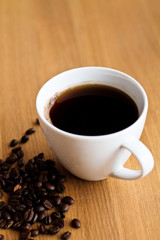 Aromatic fresh coffee in porcelain cup on wooden table