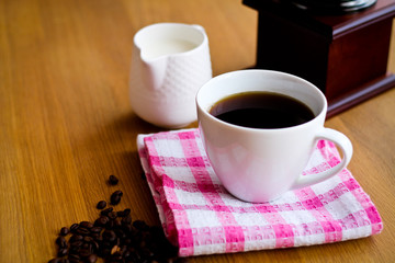 Aromatic fresh coffee in porcelain cup on wooden table