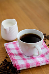 Aromatic fresh coffee in porcelain cup on wooden table
