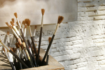 Artist Paint Brushes with White Brick Wall Background