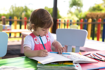 little girl drawing a colorful pictures