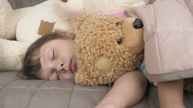 Child sleeps in toys. Adorable little girl sleeps in toys.