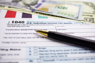 Tax Return form 1040 and dollar banknote : U.S. Individual Income.