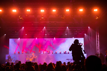 Fototapeta na wymiar Silhouette of a crowd of cheering fans during a live concert