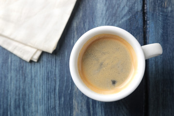 Natural espresso coffee in a ceramic coffee cup on a blue wooden table. view from above