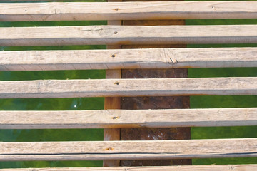 Wooden pier in the sea close-up with clear blue water under it.