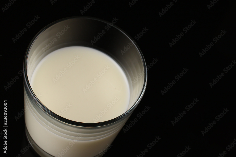 Wall mural A glass of milk on top of a dark background