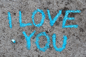 Colorful chalk drawing on asphalt: Blue words I LOVE YOU