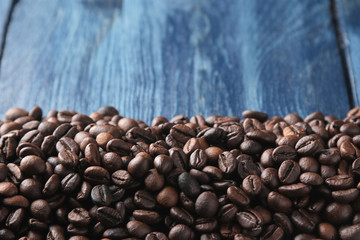 Frame of roasted coffee beans on a blue wooden table. space for text