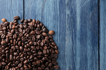 Frame of roasted coffee beans on a blue wooden table. view from above. space for text